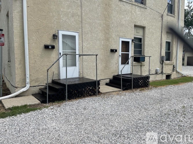 A building with a white door and a black railing.