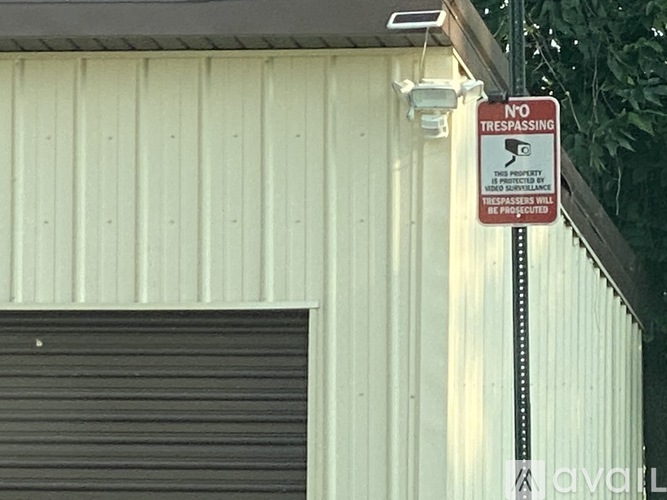 A sign on a pole outside a building warns against trespassing.