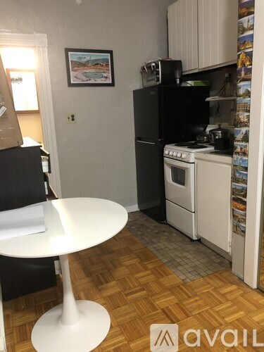 A kitchen with a white table and a fridge.