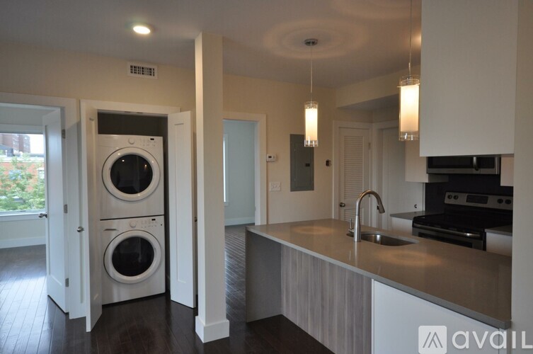 A modern kitchen with a washer and dryer built into the cabinetry.