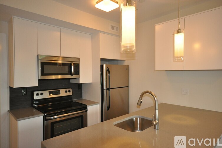 A kitchen with a stove, refrigerator, and sink.