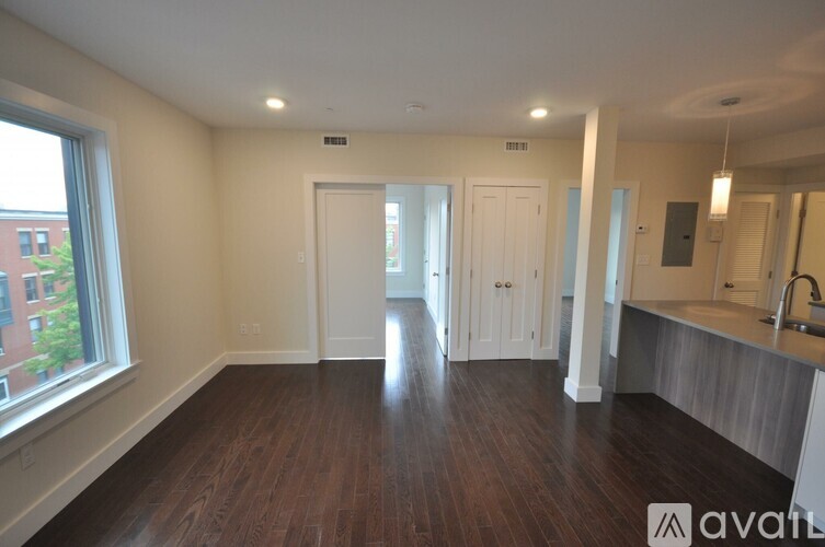 A spacious room with wooden floors and white walls.