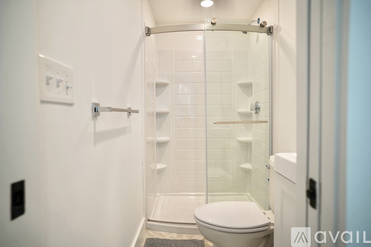A white toilet in a glass enclosed shower stall.