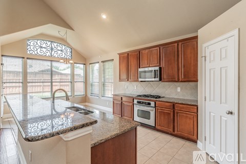 A kitchen with brown cabinets and a granite countertop.