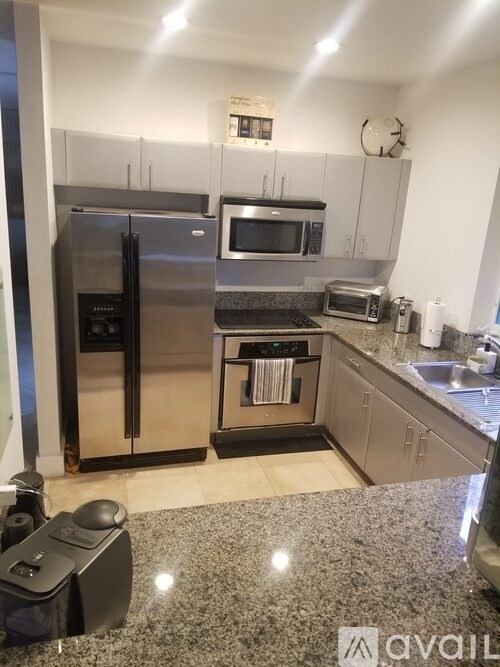 A kitchen with a granite countertop and stainless steel appliances.