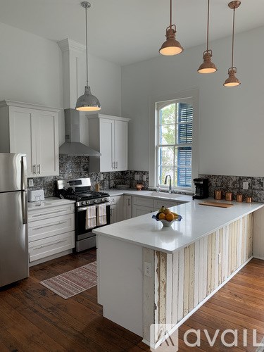 A kitchen with a white island and wooden cabinets.