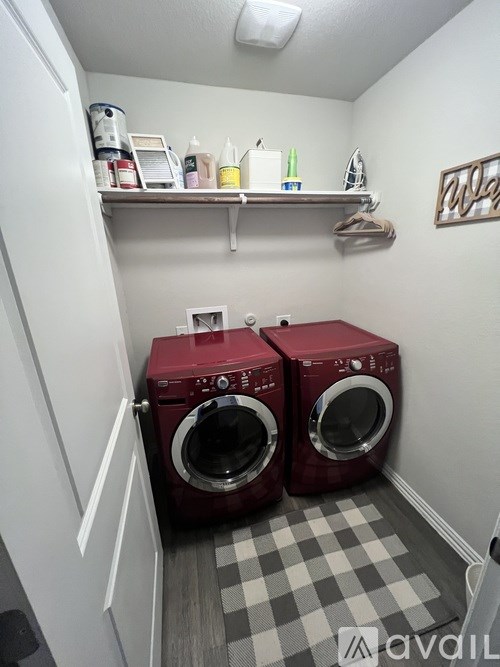 A small laundry room with two red washing machines.