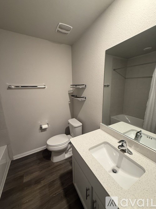 A bathroom with a toilet, sink, and mirror.