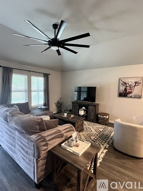 A living room with a grey couch and a wooden coffee table.
