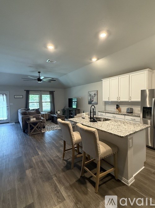A kitchen with a refrigerator, stove, and a dining table with chairs.