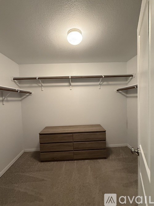 A bathroom with a walk-in shower and a towel hanging on the door.