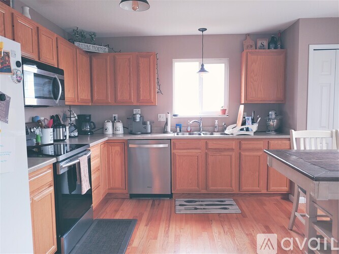 A kitchen with wooden cabinets and a black refrigerator.