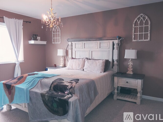 A bedroom with a large bed and a chandelier.