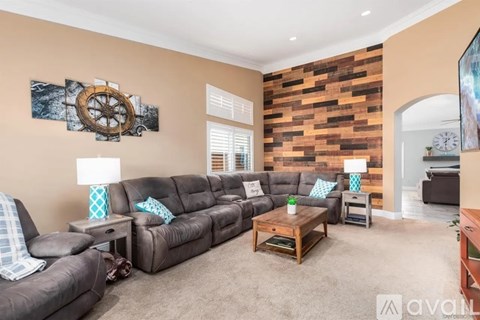 A living room with a brown leather couch and a wooden coffee table.