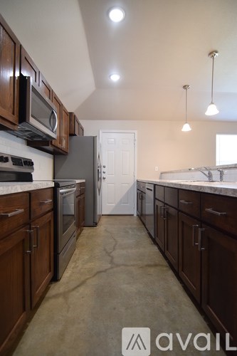 A kitchen with brown cabinets and a white door in the background.