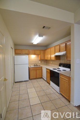 A kitchen with white appliances and wooden cabinets.
