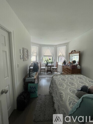 A bedroom with a bed, dresser, and mirror.