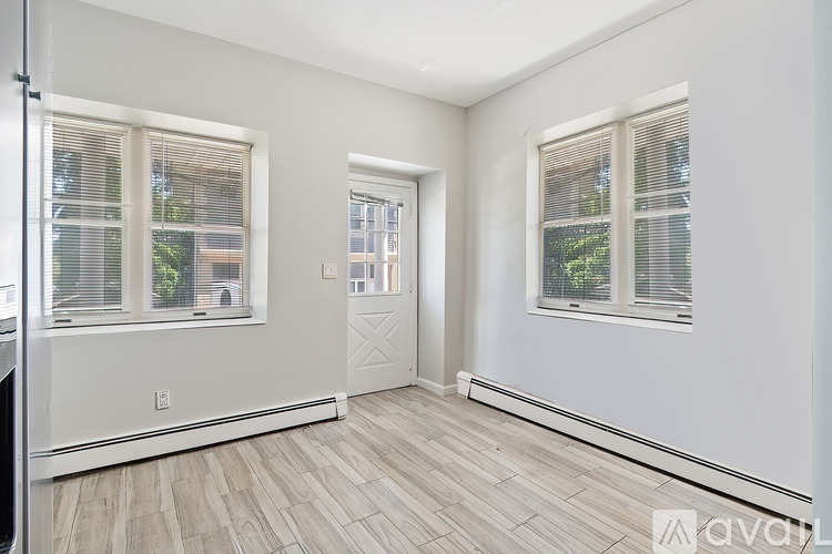 A room with a door and two windows.