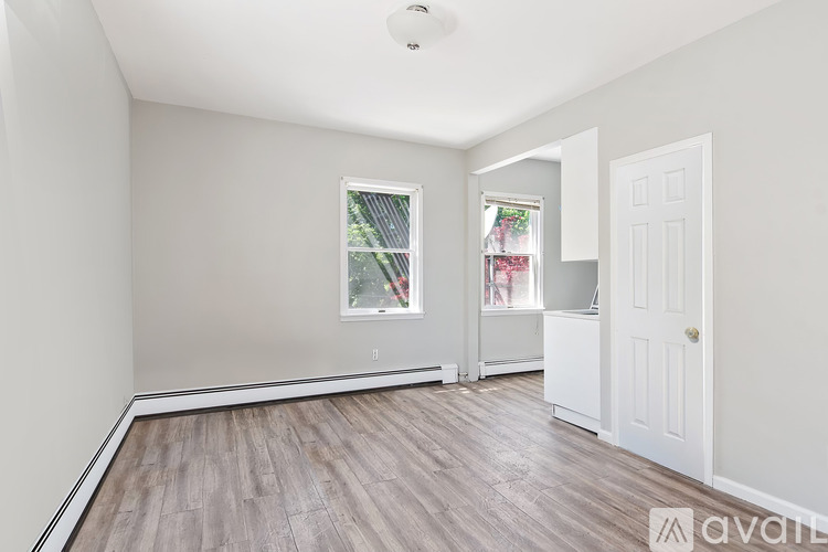 A room with a window and a door is available for rent.