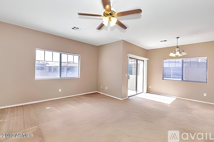 A spacious room with a ceiling fan and sliding glass doors.
