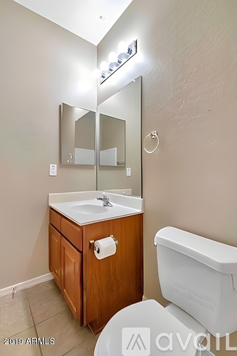 A bathroom with a white toilet and a wooden cabinet.