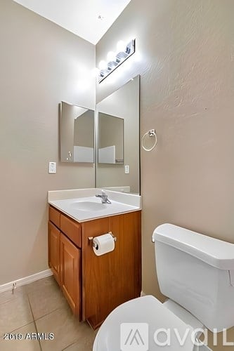 A bathroom with a white toilet and a wooden cabinet.