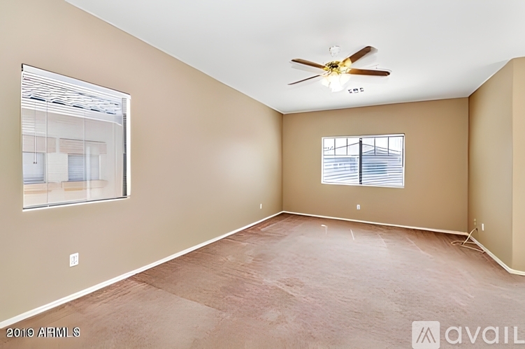 Empty room with a ceiling fan and a window.