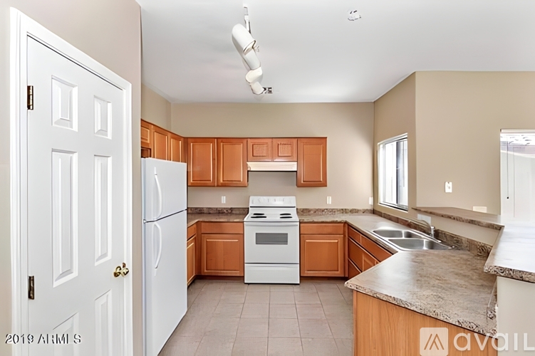 A kitchen with white appliances and wooden cabinets.