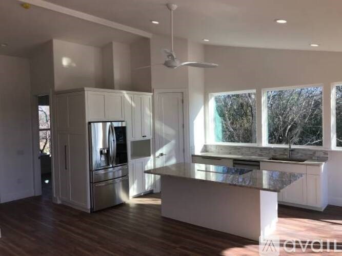 A modern kitchen with a large island and stainless steel appliances.