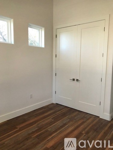 A room with a white door and two windows.