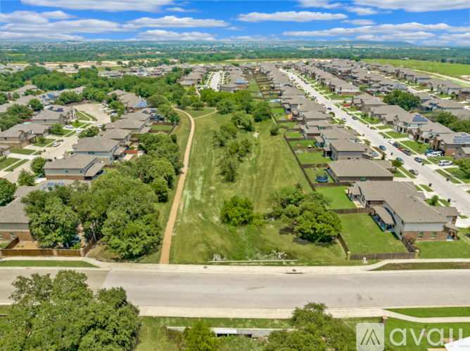 A bird's eye view of a residential area with houses, roads, and a swimming pool.