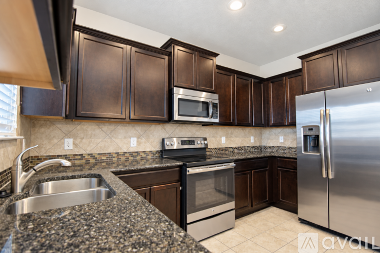 A kitchen with dark brown cabinets and a white fridge.
