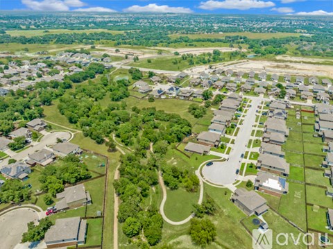 An aerial view of a large building complex surrounded by a green landscape.