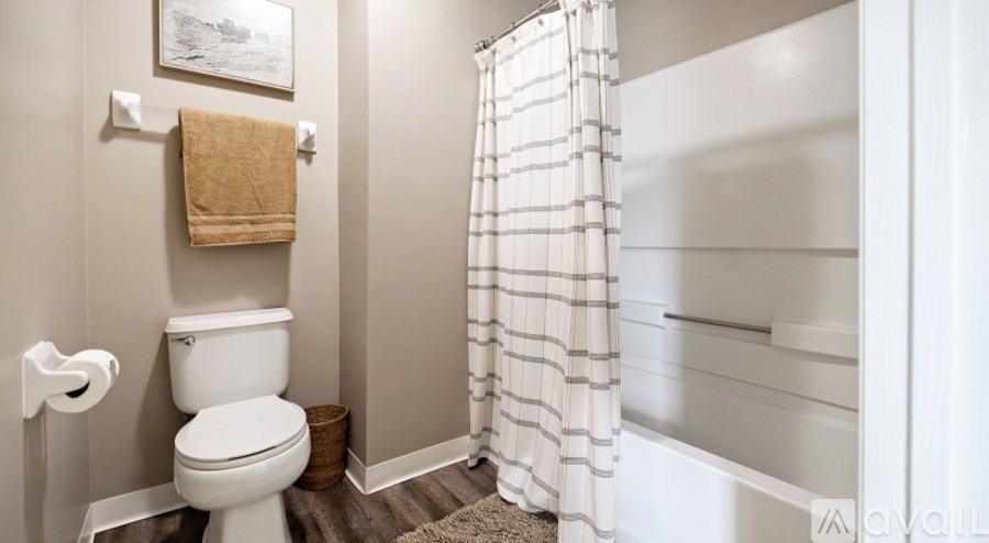 A bathroom with a toilet, a towel, and a shower curtain.