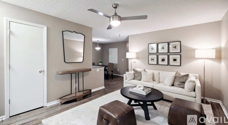 A living room with a white couch, a coffee table, and a mirror on the wall.