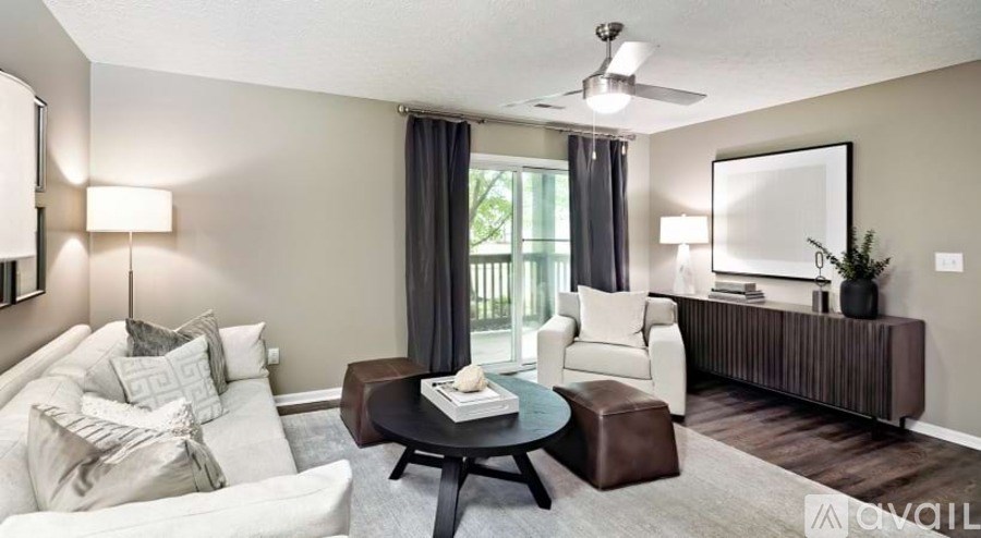 A living room with a white couch, a coffee table, and a ceiling fan.
