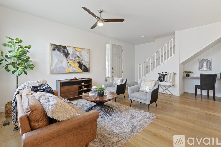 A living room with a brown leather couch, a coffee table, and a painting on the wall.