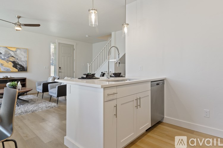 A kitchen with white cabinets and a wooden floor.