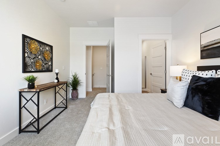 A bedroom with a large bed and a painting on the wall.