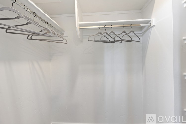 A row of clothes hangers are on a white rod.