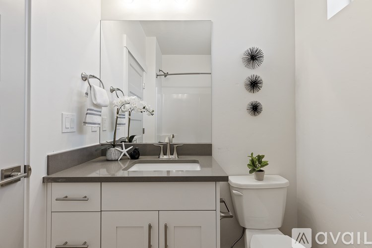 A bathroom with a toilet, sink, and mirror.