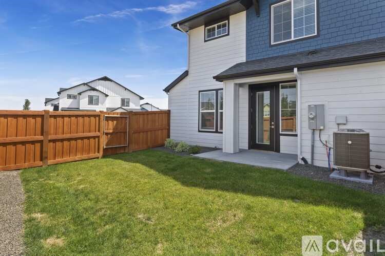 A white house with a brown fence and a grey roof.