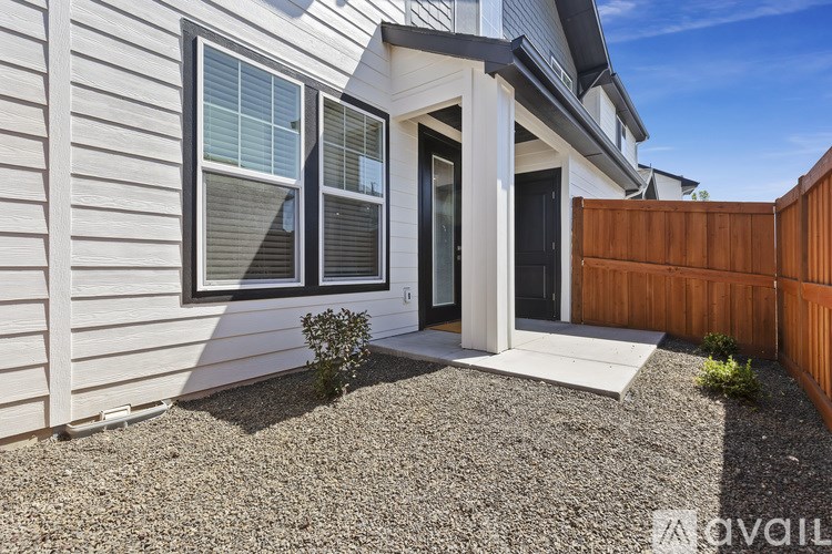 A house with a white front door and a small bush in front of it.