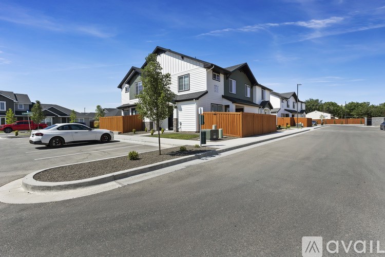 A row of houses with a car parked in front of the first house.