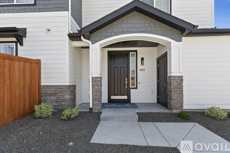 A house with a brown front door and a wooden fence.