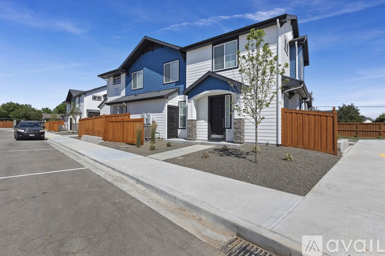 A row of houses with a car parked in the driveway.