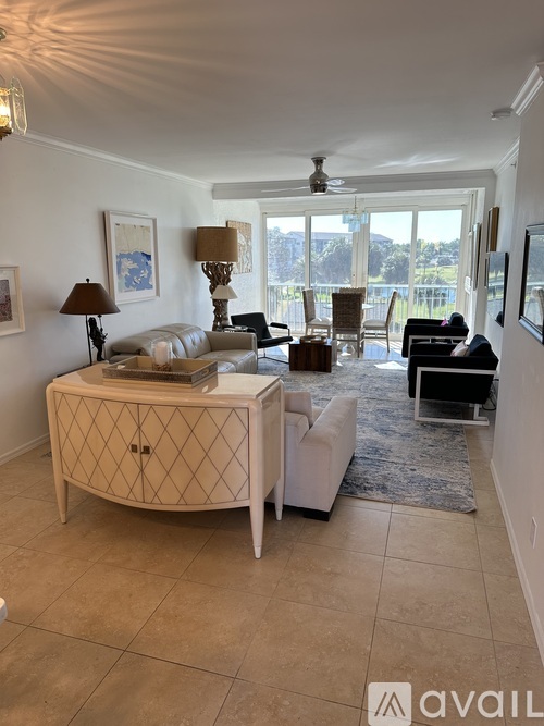 A living room with a white sofa, a wooden side table, and a rug.