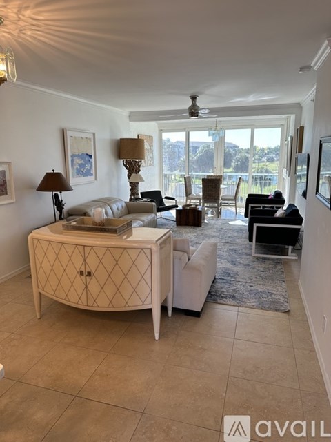 A living room with a white sofa, a wooden side table, and a rug.