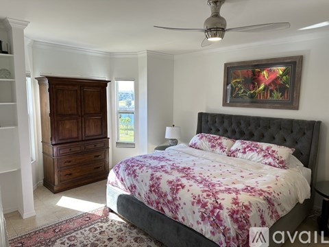 A bedroom with a large bed and a wooden wardrobe.