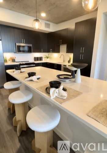 A kitchen with black cabinets and white countertops.